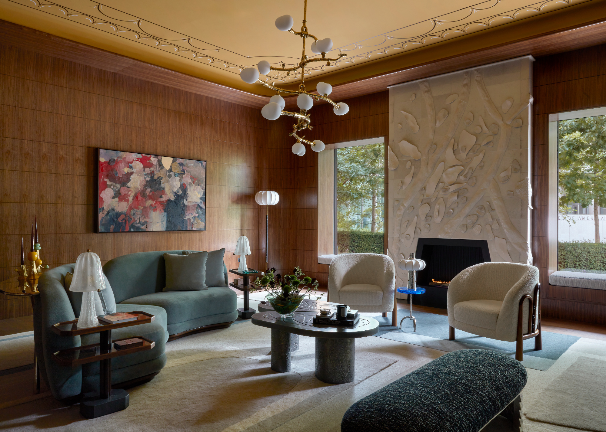 wooden veneer walls in a formal living room with a stucco fire place, curved art deco furniture and a chandelier in the centre