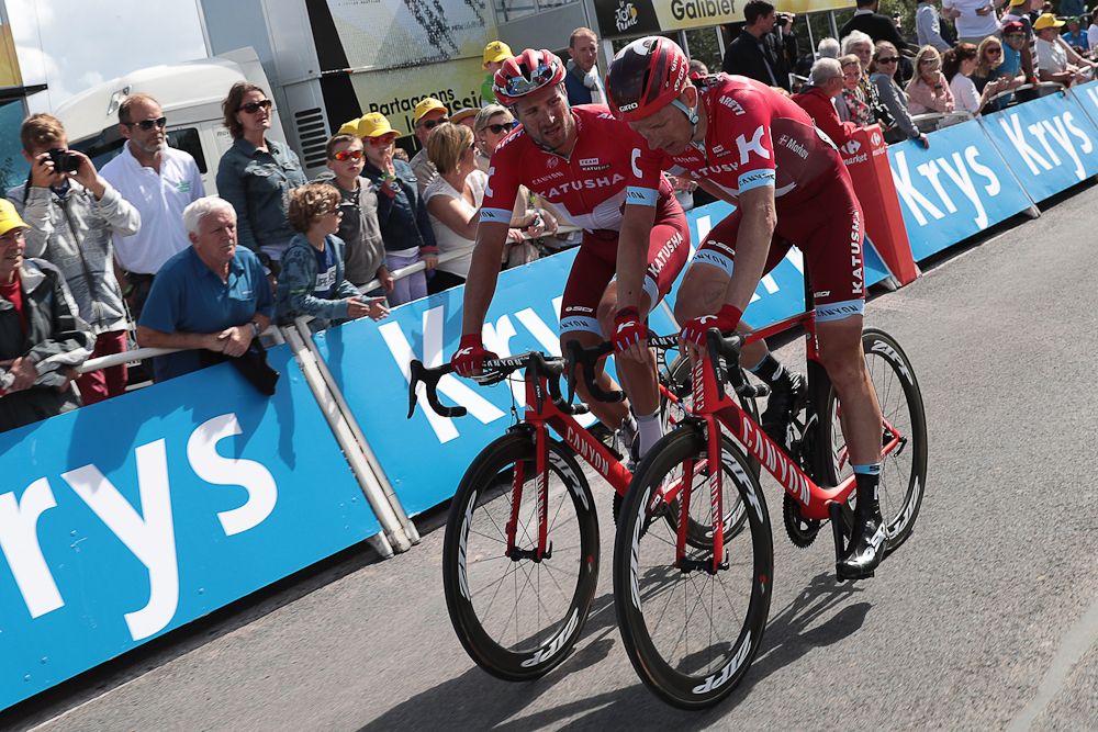 Michael Morkovrides next to his teammate Austria's Marco Haller, after a falling during the 188 km first stage of the 103rd edition of the Tour de France