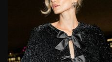 A female model wearing a sparkly top with silk ribbon bows from Monsoon.