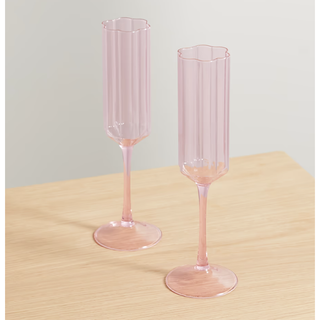 two pink flute glasses with a wave edge design