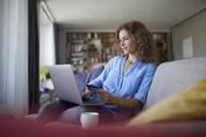 Budgeting apps: Smiling woman doing online shopping on laptop at home