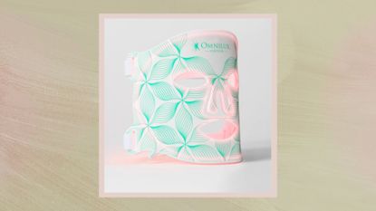 A white and mint green coloured Omnilux Contour LED Face Mask on a gradient green background. 