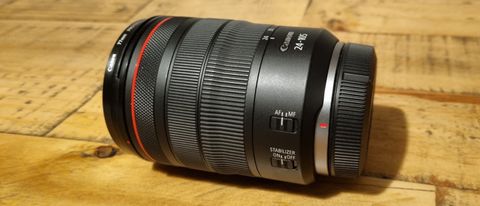 The Canon RF 24-105mm f/4L IS USM on its side on a wooden table