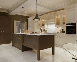 Breakfast bar kitchen layout ideas illustrated in a traditional scheme with white and brown units and black pendant lighting.