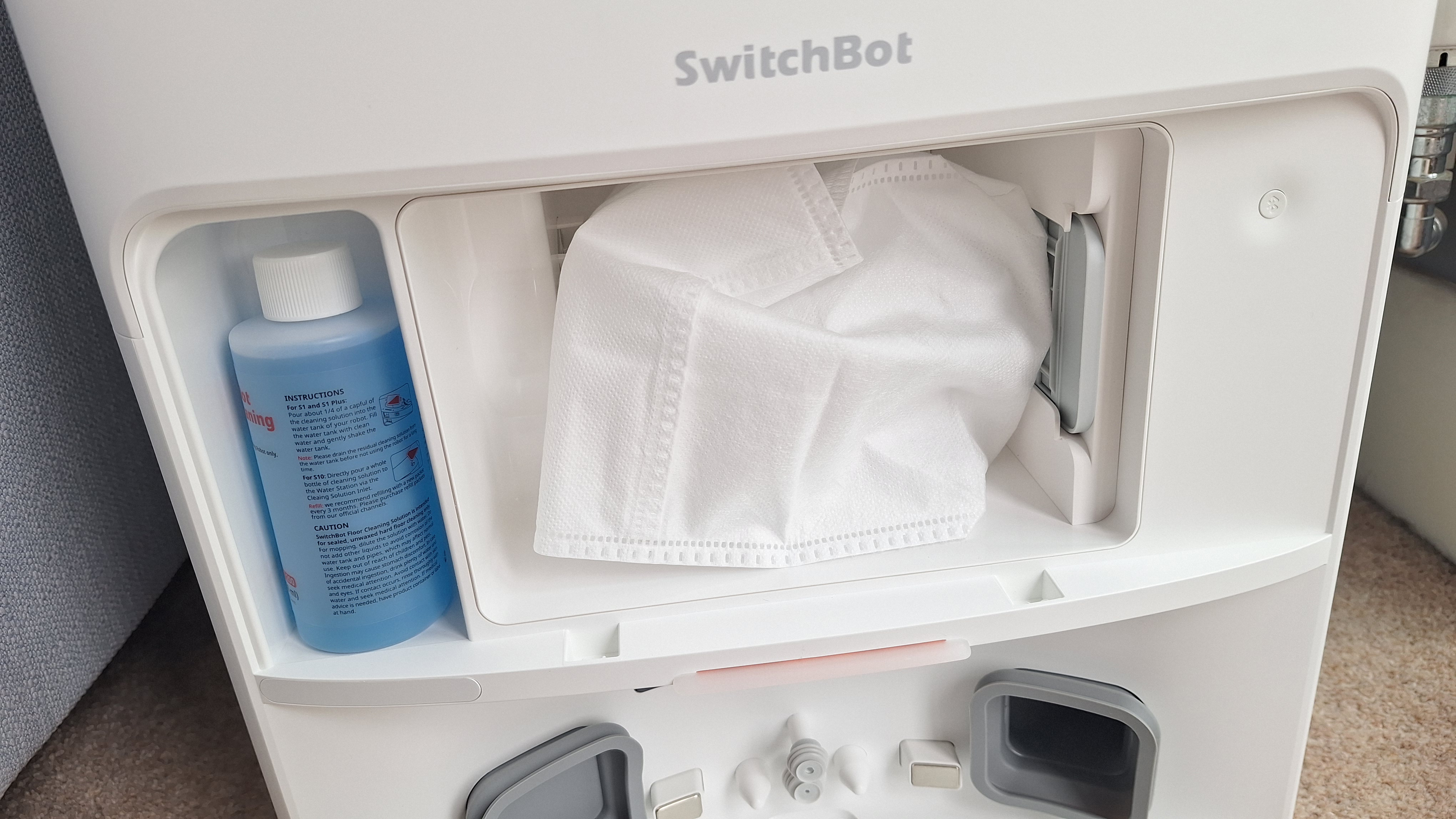 Front of SwitchBot S20 dock with cover removed to show dust bag and cleaning fluid