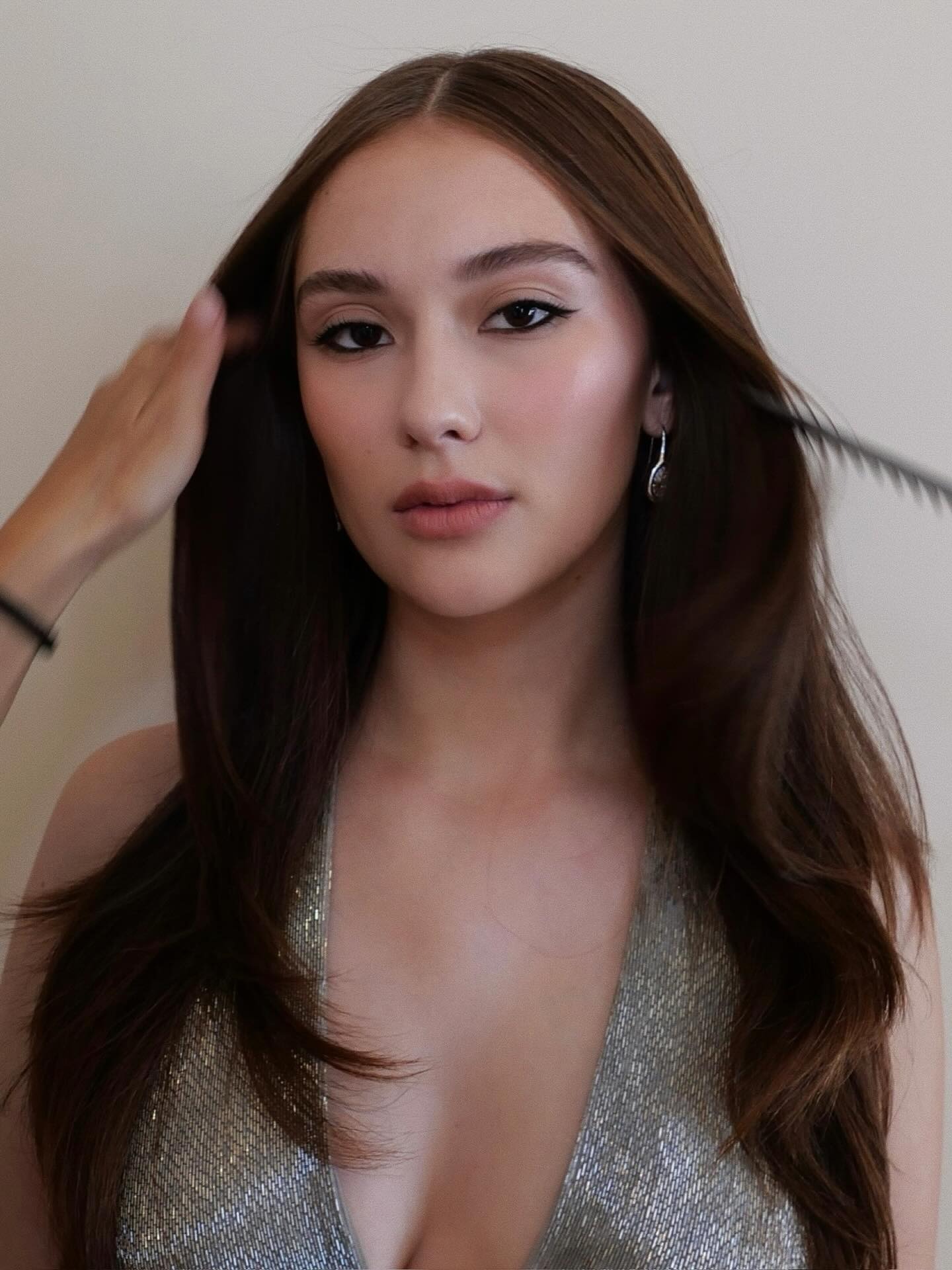 Lola Tung with long brunette hair and subtle highlights