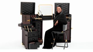 pat mcgrath in front of louis vuitton trunks