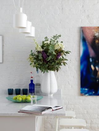 white vase filled with flowers in a white kitchen