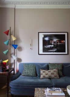 Do smart light bulbs use electricity when off Living room with soft beige walls and navy blue velvet sofa with colorful floor lamp