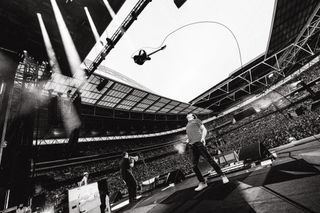 The band Blur performing on stage throwing a guitar in the air