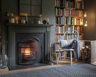 Home library by fireplace with chair