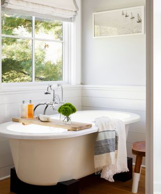 White bathroom with shiplap paneling and roll top bath