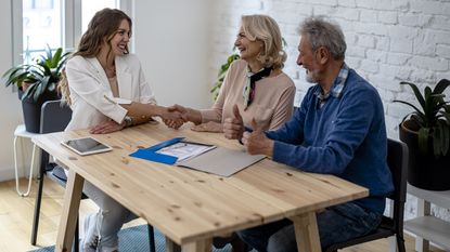 A financial planner meets with clients in her office to talk about estate planning.