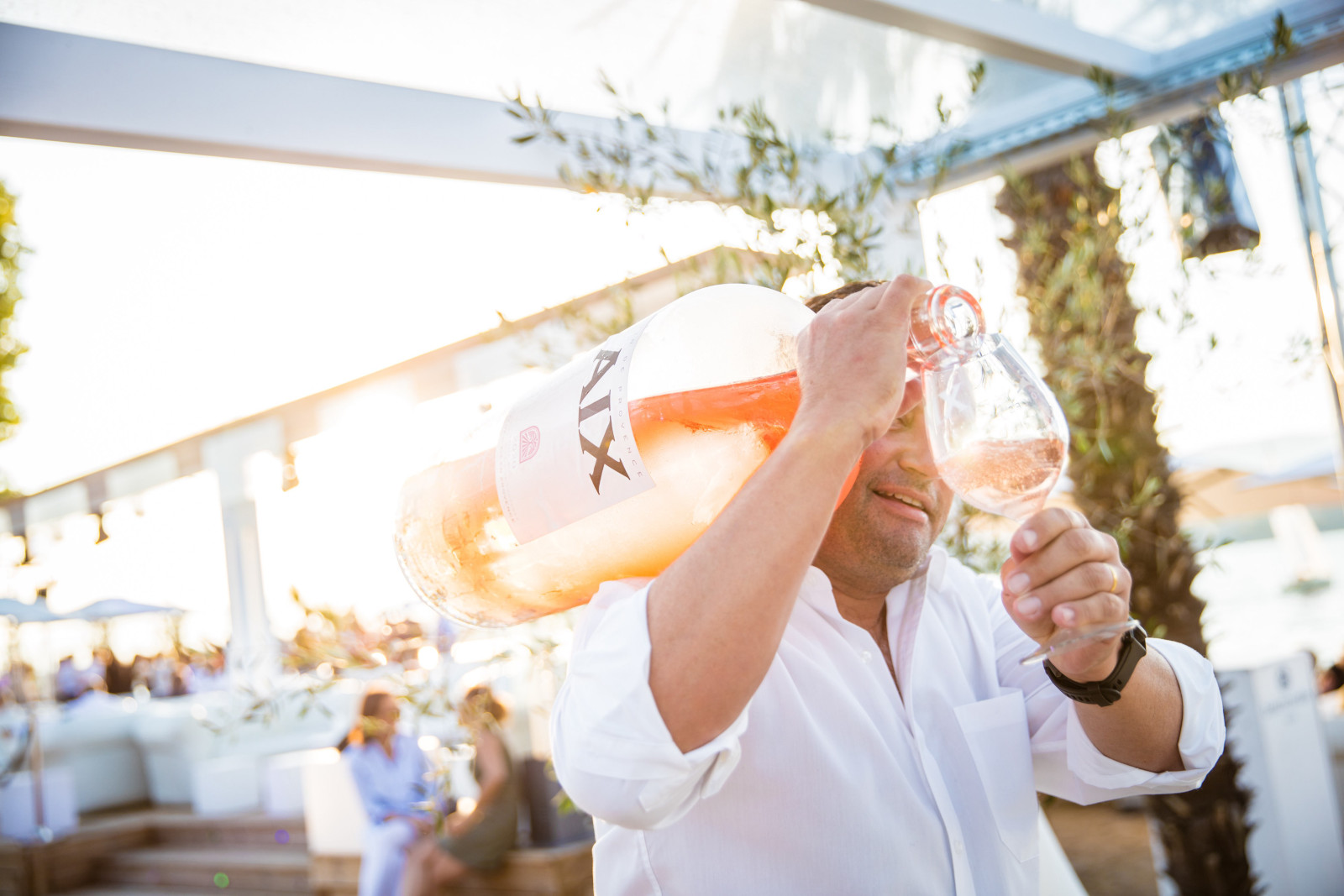 Man holds giant bottle of AIX Rosé on shoulder