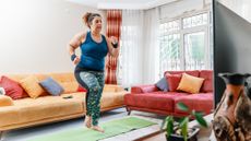 Woman exercising in front of TV in a living room