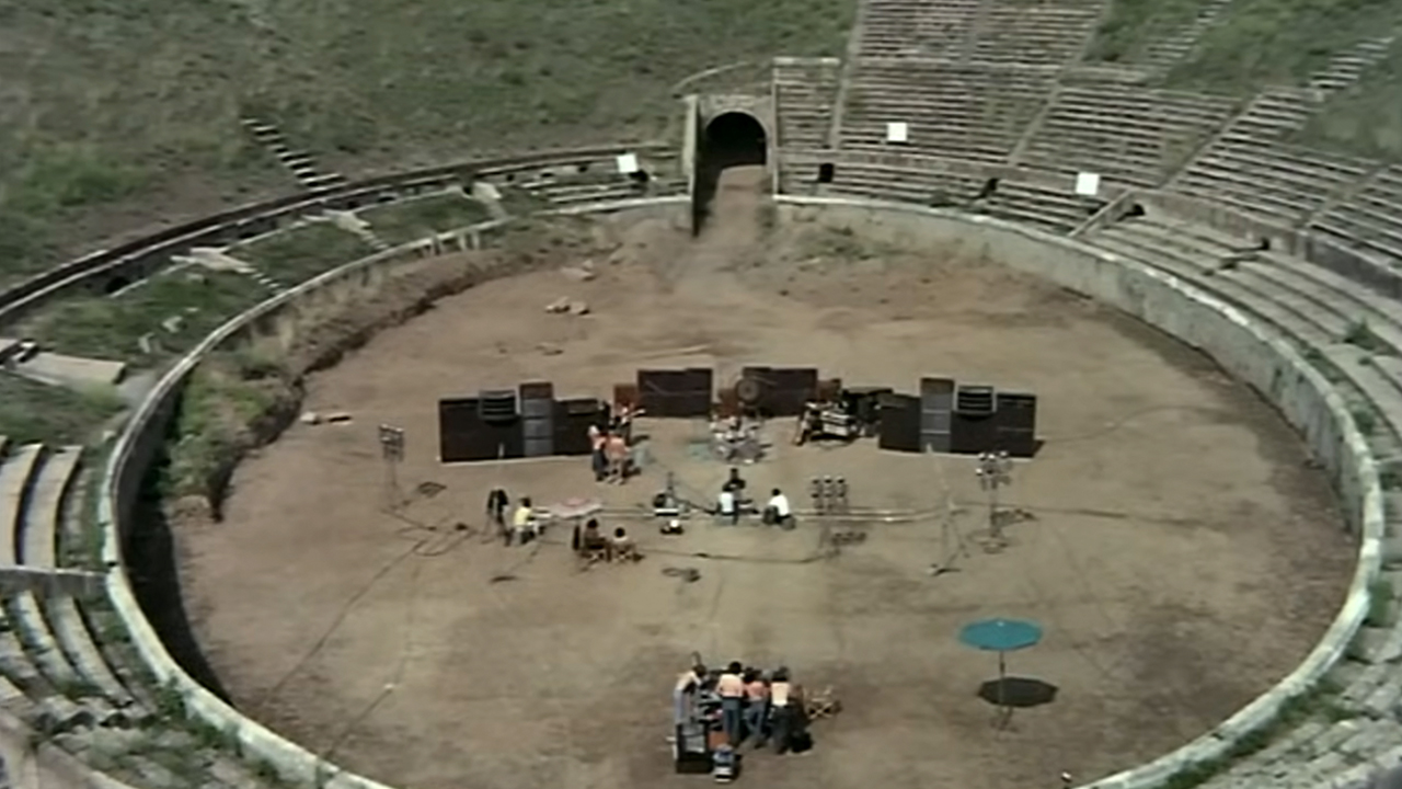 A wide shot of Pink Floyd in the middle of a ruin at Pompeii