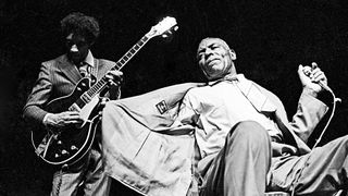 Photo of Howlin' Wolf performing live on stage with guitarist Hubert Sumlin (1931-2011) behind