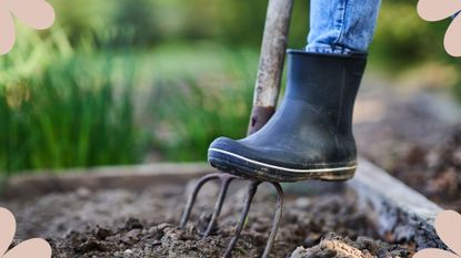 woman pushing fork down into ground with welly on 