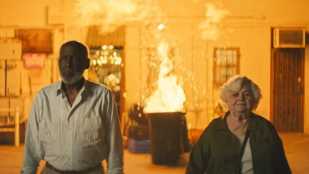 Richard Roundtree and June Squibb walking away from fire in Thelma