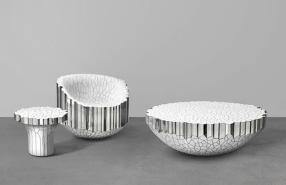 LefT: A white mushroom shaped stool. Middle: A marshmallow shaped chair: Right: A semi-val shape. All objects are white with metallic effects. 