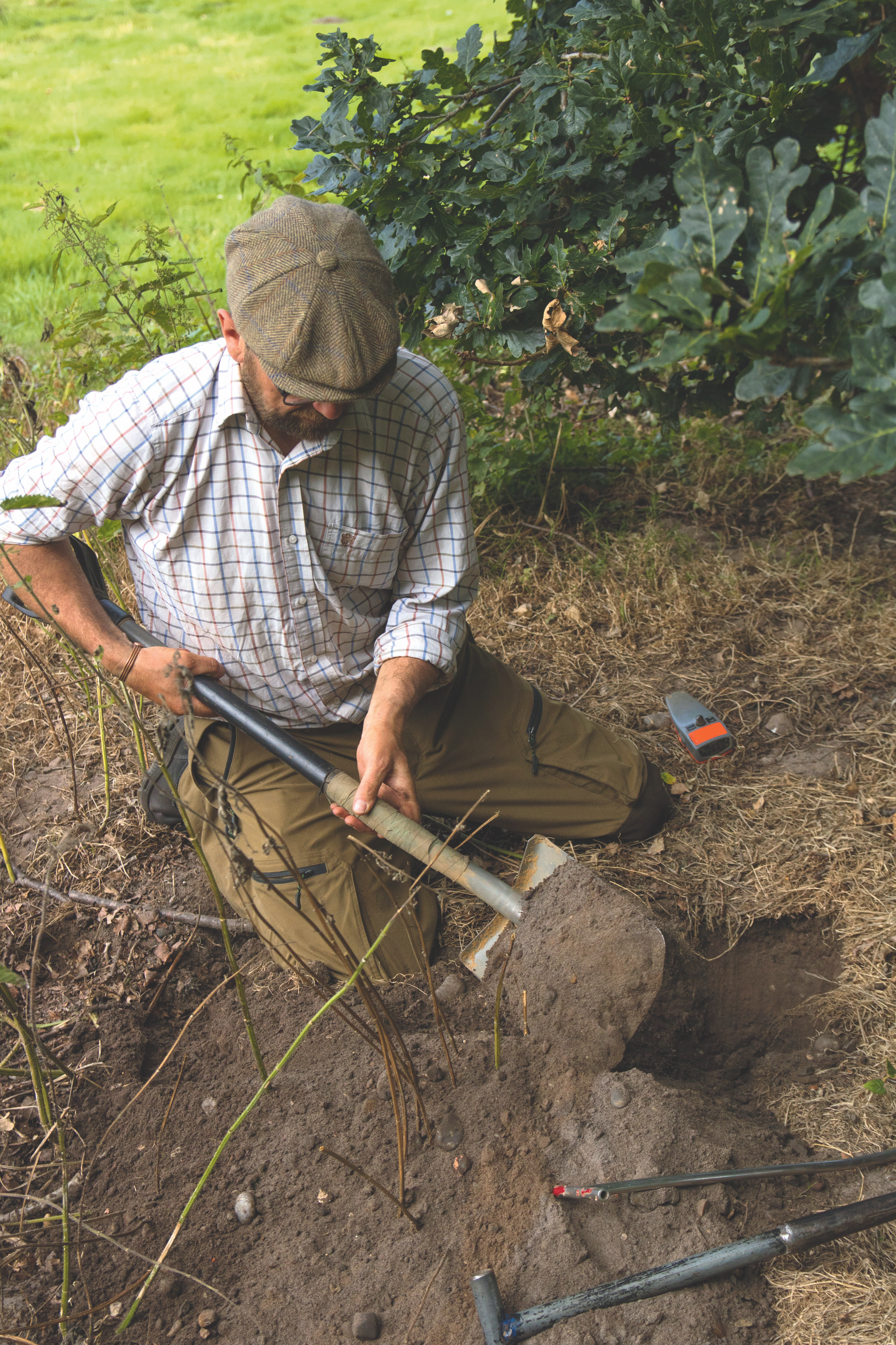 An example of how to landscape a backyard showing a gardener digging soil