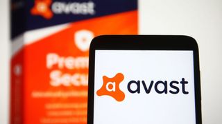 A close up of a smartphone with the Avast logo displayed, with a blurred Avast software box in the background