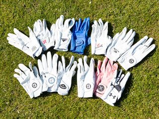 selection of golf gloves lying on the grass