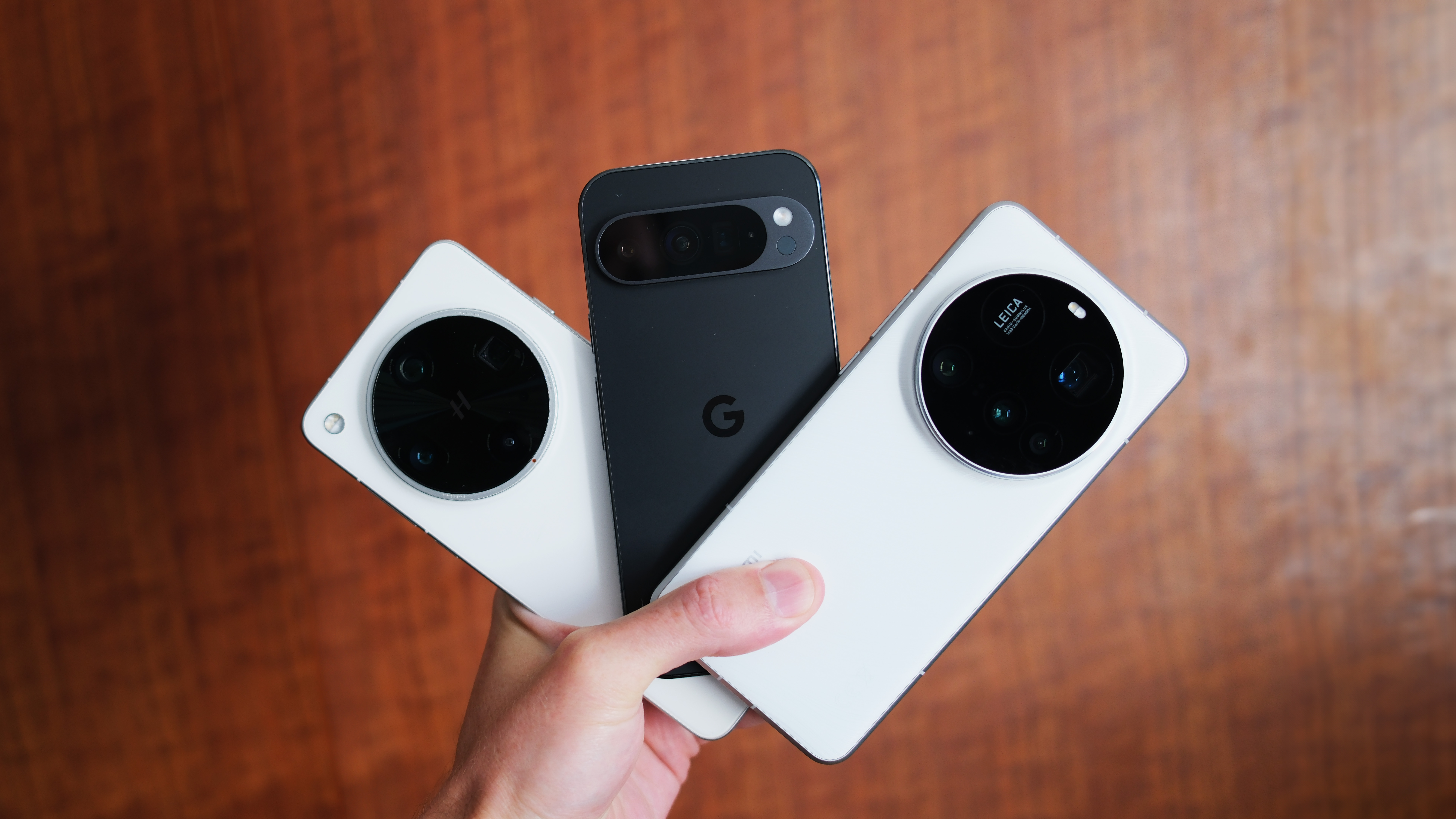 Google Pixel 9 Pro, Oppo Find X8 Ultra, and Xiaomi 15 Ultra phones all held in a hand