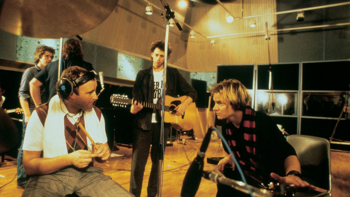 Phil Collins, Bob Geldof and Sting stand together during a Band Aid recording session