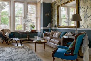 living room in victorian home with blue walls and floral wallpaper