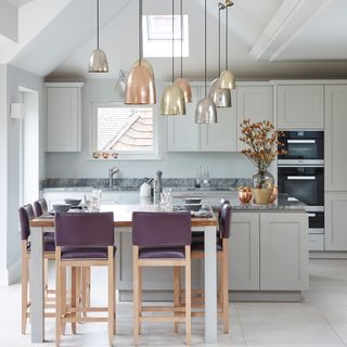 a traditional style kitchen with contemporary lighting and island