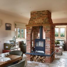 living dining area with brick log burner in-between dining and living spaces