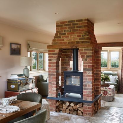 living dining area with brick log burner in-between dining and living spaces