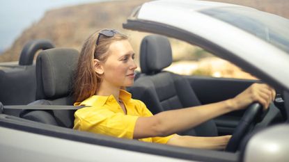 Woman in a yellow T-shirt driving a car