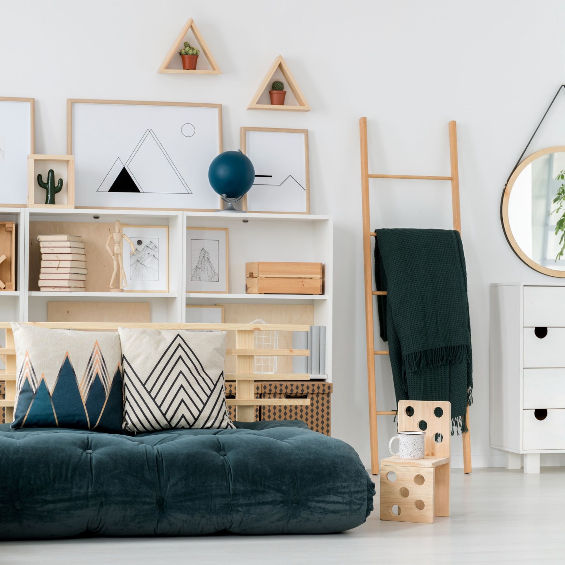 Green futon bed, patterned cushions, ladder shelf, shelving unit
