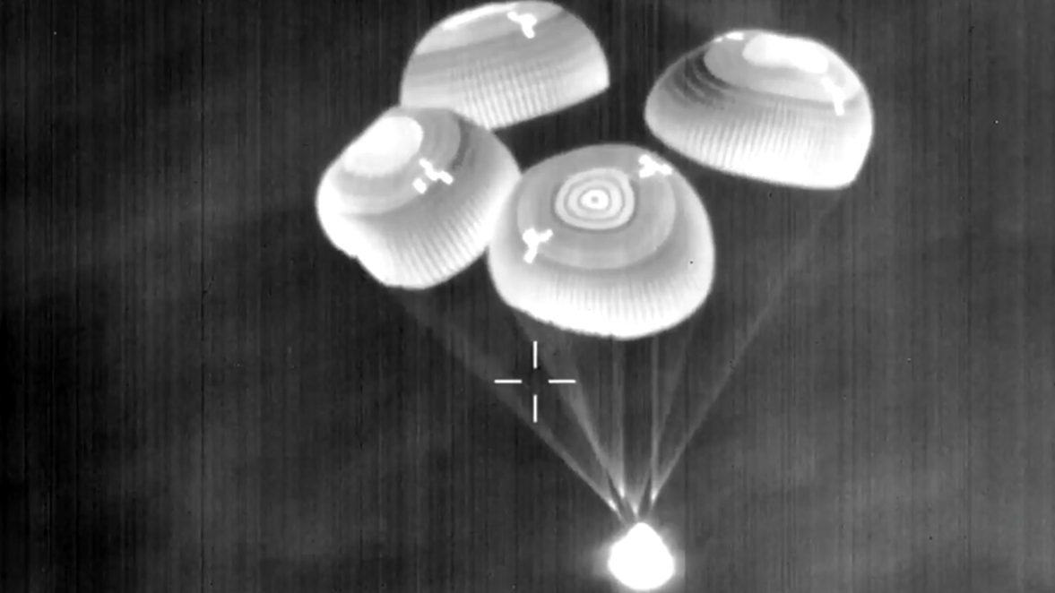 A sight of the night's sight of a spacox of dragon traceapreless land back under the deployment of the drog parachutes.