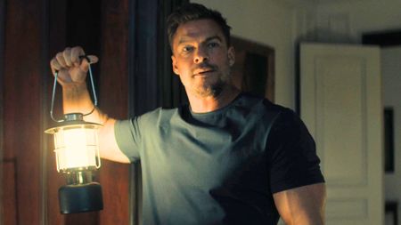Reacher holds a lantern