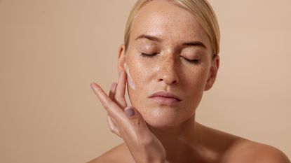 Best serum for pigmentation - woman applying a cream to her skin - getty images 1347066292 