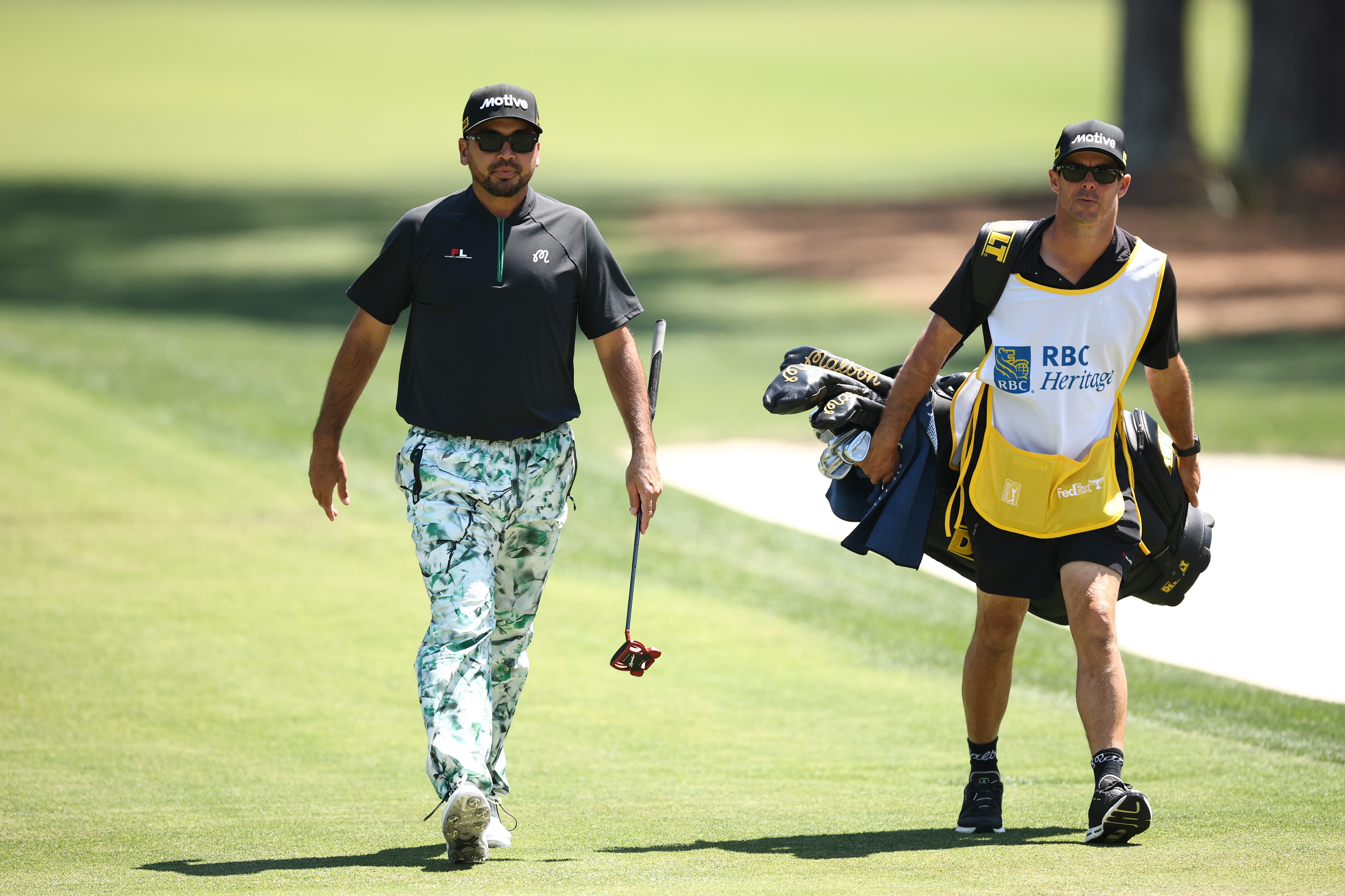 Jason Day walks alongside his caddie