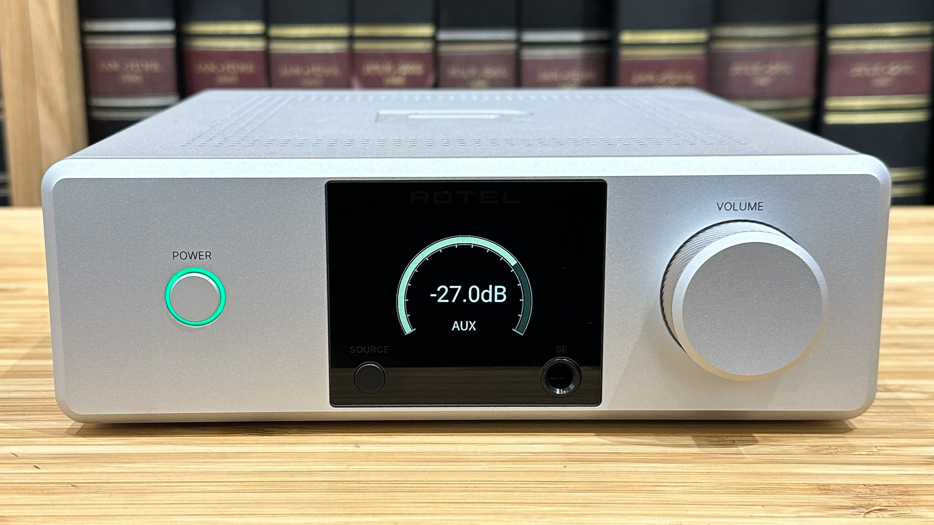 Rotel DX-5 integrated amplifier on wooden hi-fi rack in front of bookcase