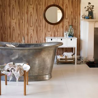 bathroom with wooden wallpaper bathtub white drawer and white flooring