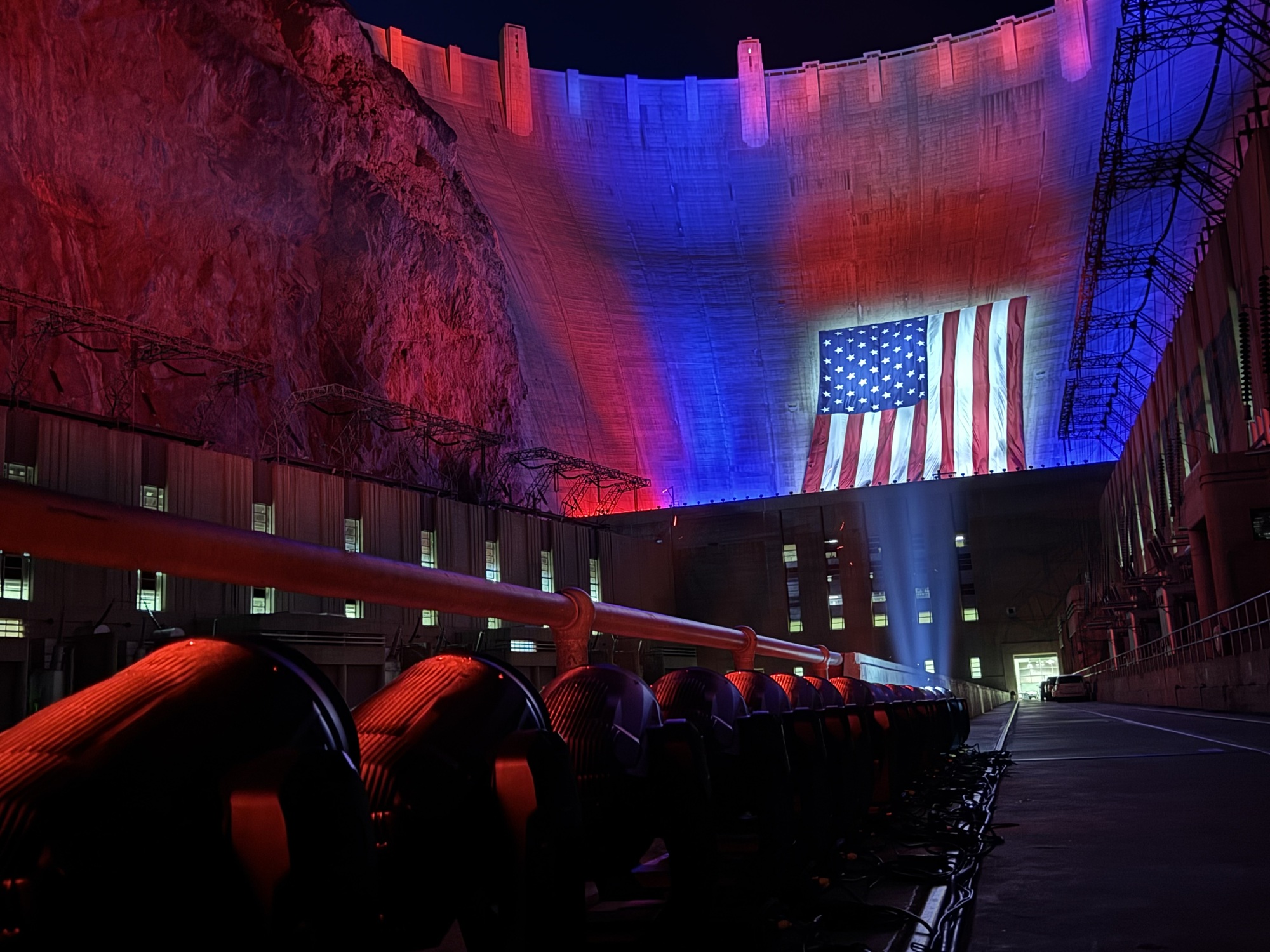 The Hoover Dam lit up in red, white, and blue with the American flag for the 250th anniversary.