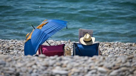 A man reads a newspaper on Chesil Beach