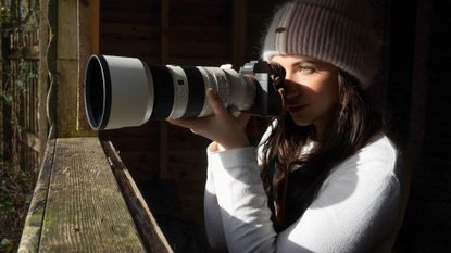 photographer Kimberley Lane using a camera and long lens in a bird hide