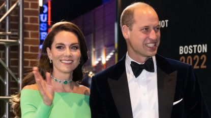 Kate Middleton waves while wearing a bright green dress and an emerald choker while husband Prince William wears a tuxedo