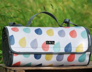 Decorative raindrop print rolled up picnic blanket with dark grey straps