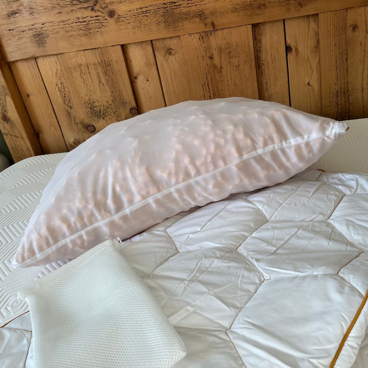 HoneyFoam pillow with outer cover, inner cover and storage bag on bed