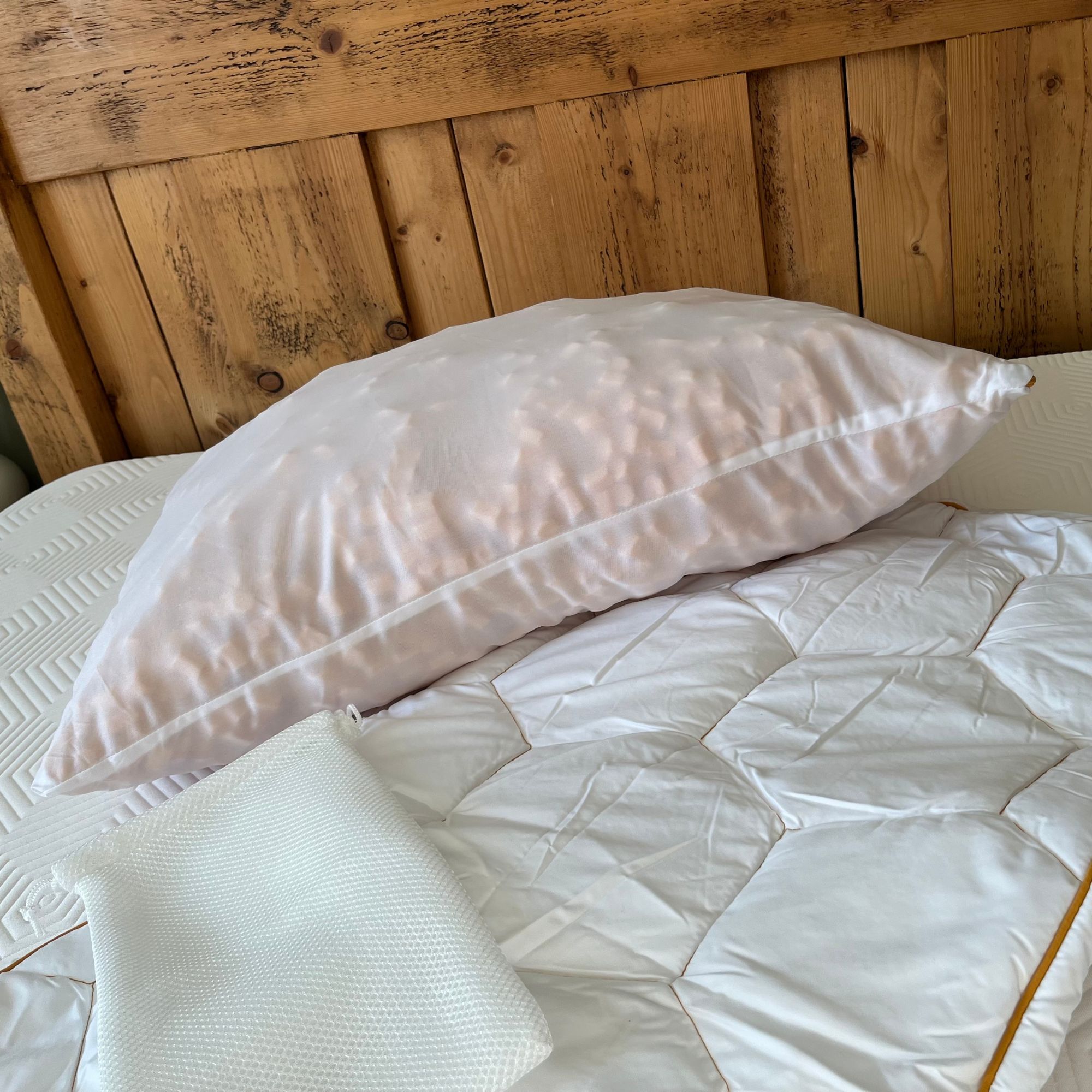 HoneyFoam pillow with outer cover, inner cover and storage bag on bed