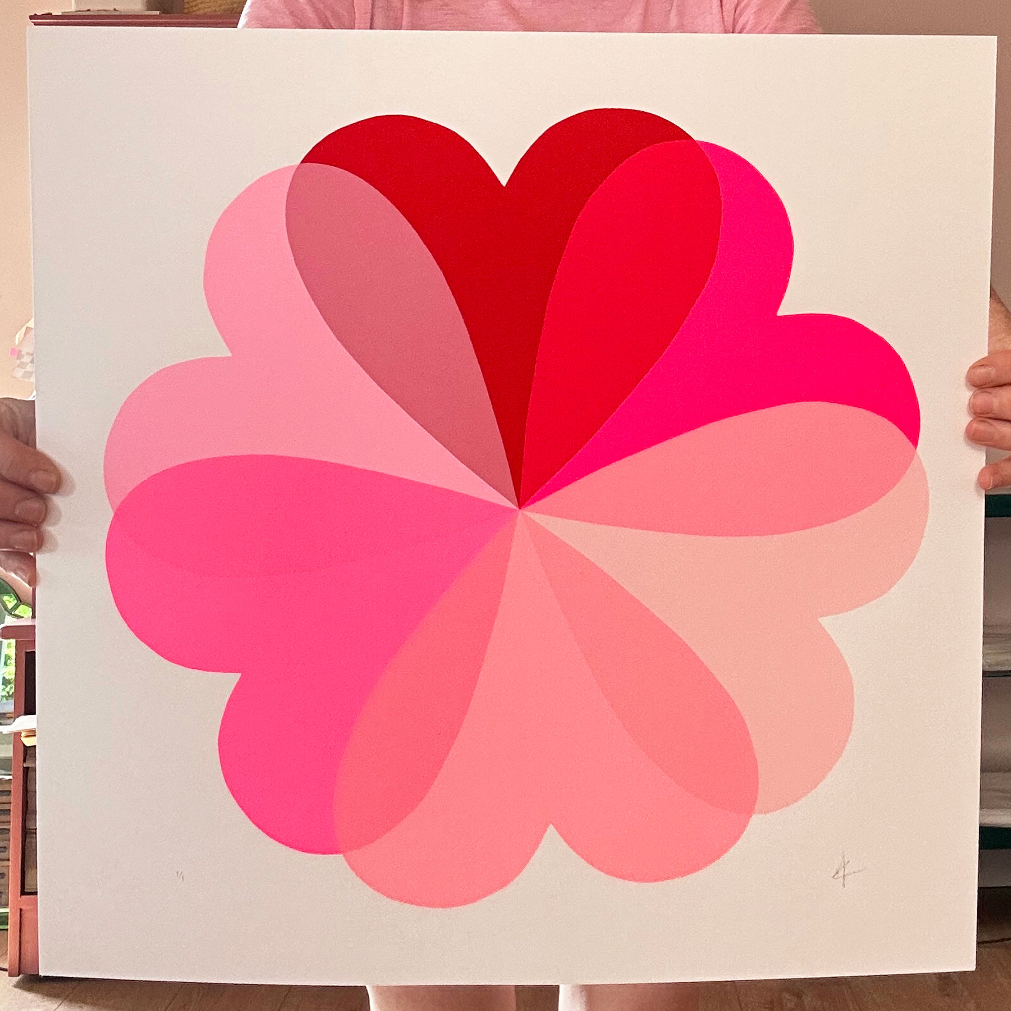 Pink graphic artwork of flower shape made up of hearts