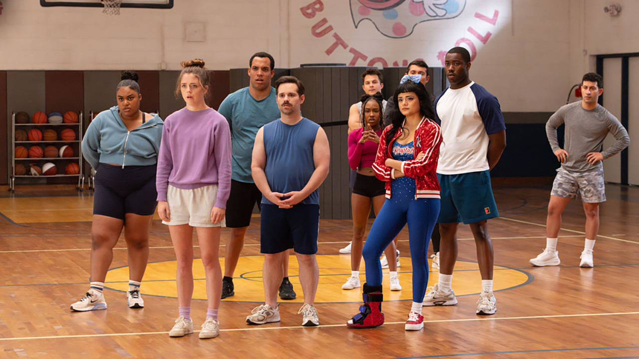 बटणे डेटोना ऑन स्टंबलच्या पुढे एक आनंददायी दिनचर्या तयार करतात. ते जिममध्ये उभे आहेत.